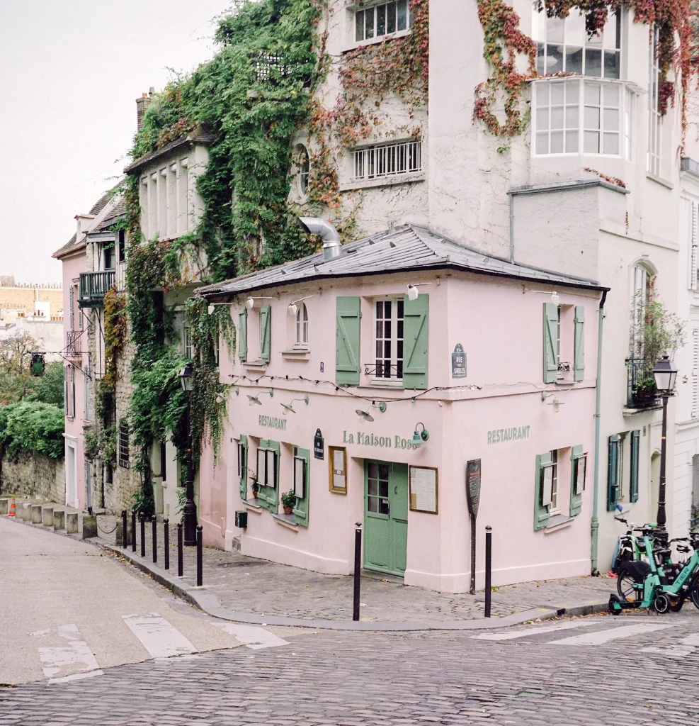 Charming Parisian building covered in vines and shutters.