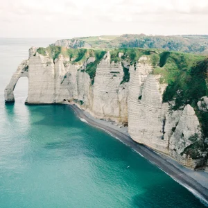Panoramic coastal cliffs with turquoise water.