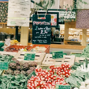 Colorful produce stand at a market with chalkboard signage.