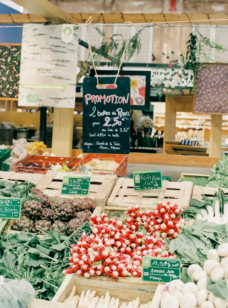 Colorful produce stand at a market with chalkboard signage.
