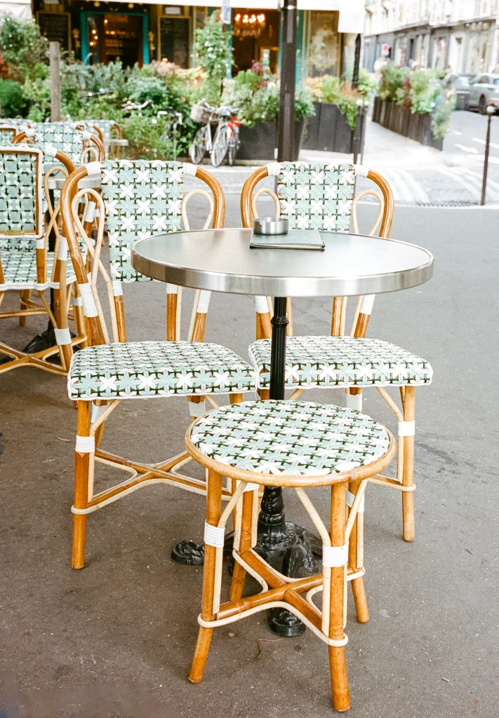 Outdoor café with woven rattan chairs and small round table.