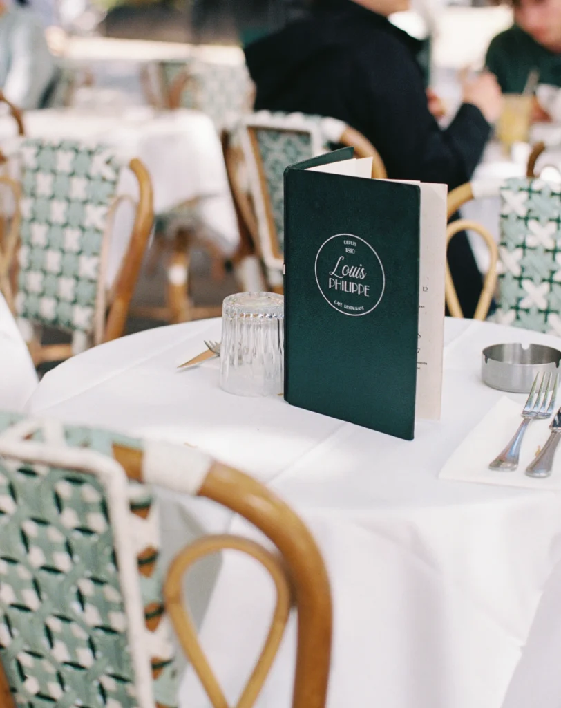 Elegant French bistro table set with green-and-white menus.