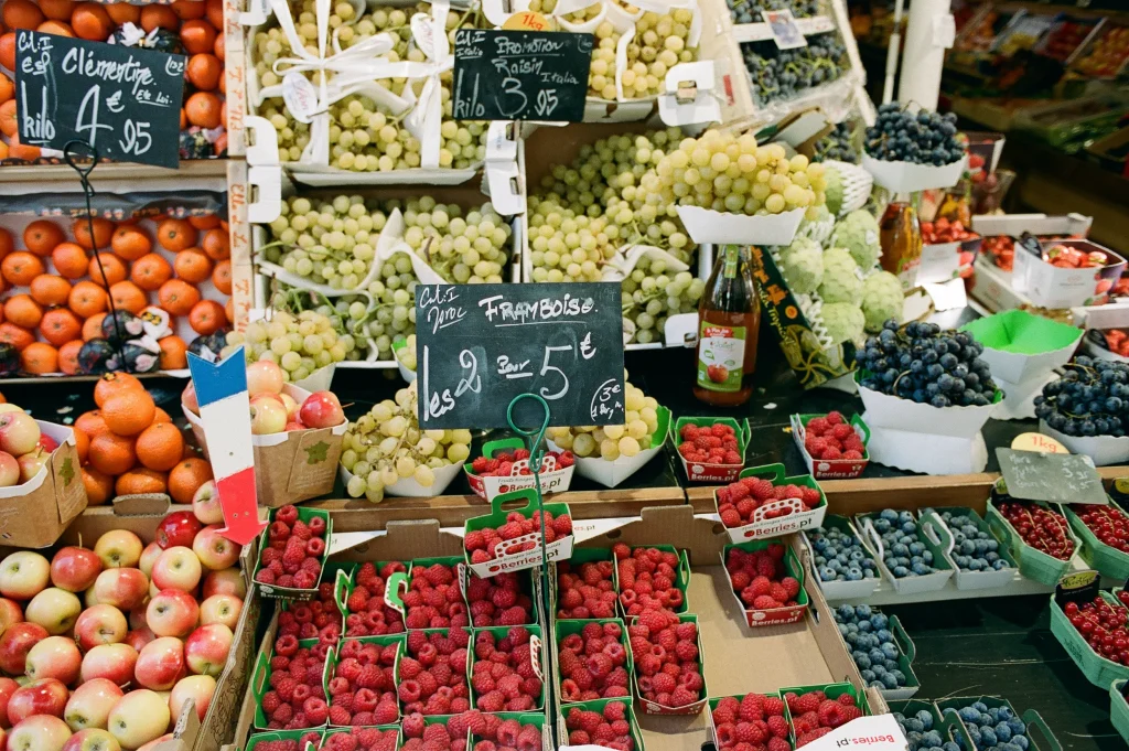 French market stall selling fresh berries and cheese.