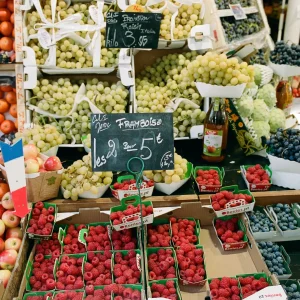 French market stall selling fresh berries and cheese.