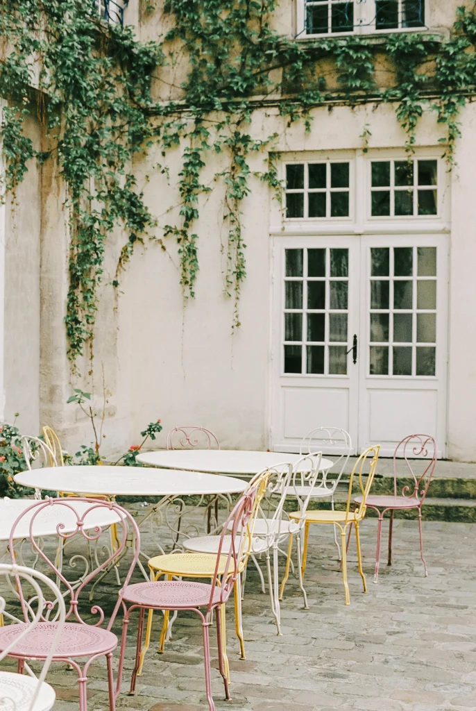 Minimalist patio with white door and metal café chairs.