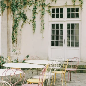 Minimalist patio with white door and metal café chairs.