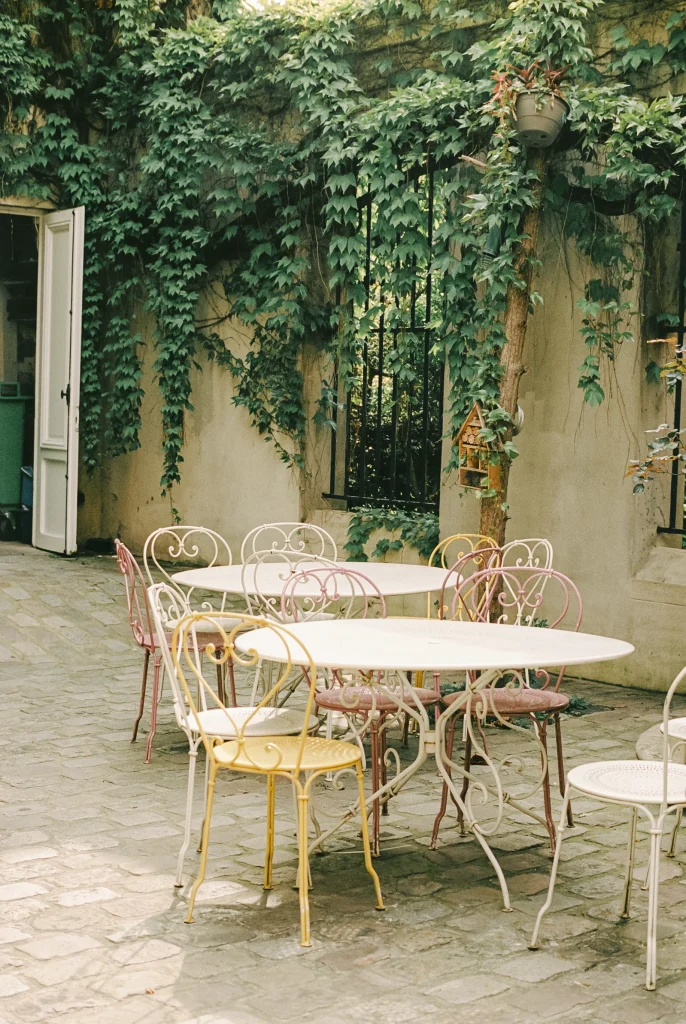 Quiet café courtyard with vintage metal chairs and climbing ivy.