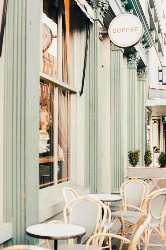 Outdoor café seating with pale green tones – quaint France travel photography, wall art.
