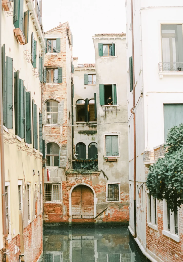 Worn-down brick buildings with windows in Venice's historic district.